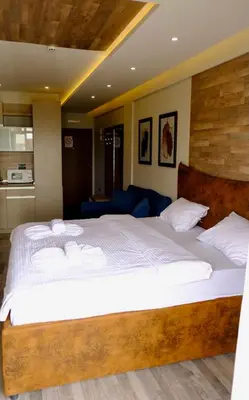 a bedroom with a large bed with white sheets at Milmari Premier 13 in Kopaonik
