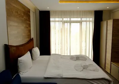 a bedroom with a bed with white sheets and a window at Milmari Premier 13 in Kopaonik