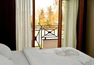 a bedroom with a bed and a view of a balcony at Milmari Premier 13 in Kopaonik