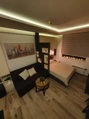 a bedroom with a bed and a couch and a table at Apartman Šmizla N lux - Milmari Resort in Kopaonik