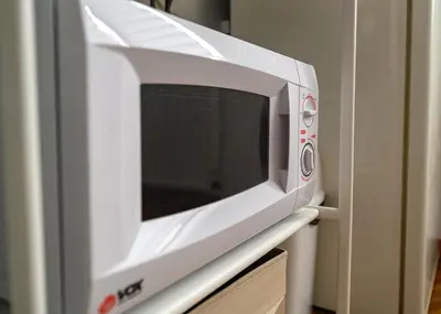 a microwave oven sitting on top of a cabinet at Center Retro Apartment in Niš