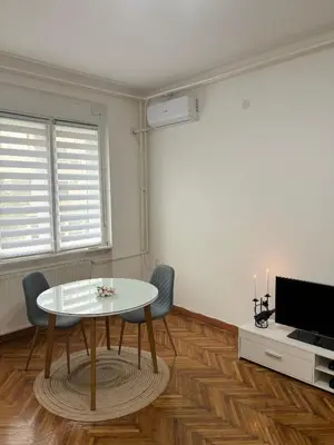 a living room with a table and a tv at Center Retro Apartment in Niš
