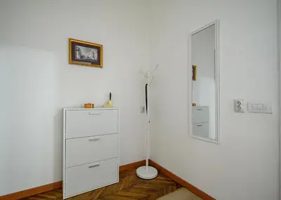 a room with a white dresser and a mirror at Center Retro Apartment in Niš