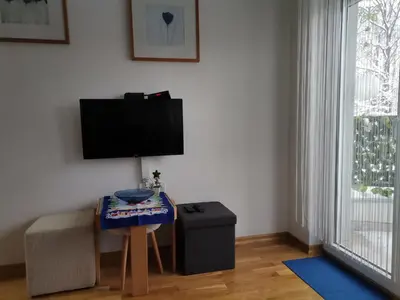 a living room with a table and a tv on a wall at Vidikovac in Vrnjačka Banja