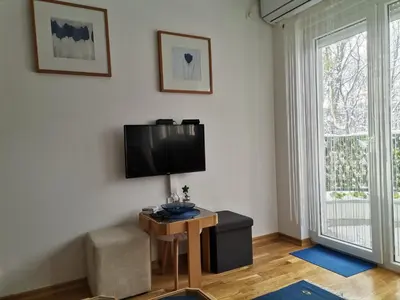 a living room with a television and a table with a chair at Vidikovac in Vrnjačka Banja