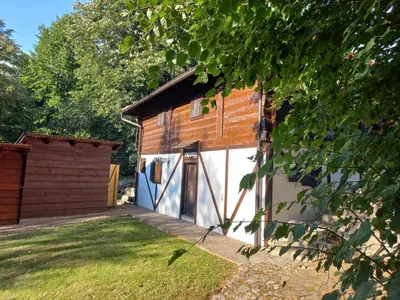 a wooden shed with a door and a yard at Vikendica Bajka in Despotovac