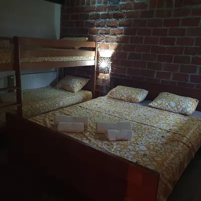 two twin beds in a room with a brick wall at Vikendica Bajka in Despotovac