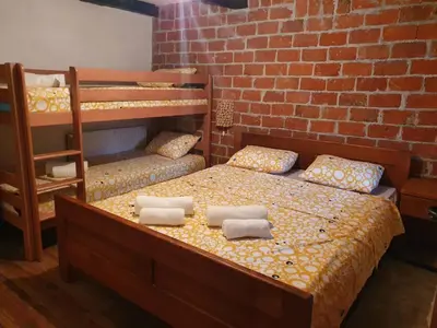 a bedroom with two bunk beds and a brick wall at Vikendica Bajka in Despotovac