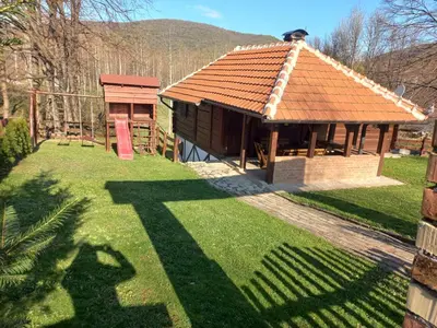 a small house with a brown roof on a yard at Vikendica Bajka in Despotovac