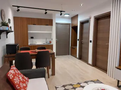 a living room and kitchen with a table and chairs at Apartman M&S - Zoned 2 in Kopaonik