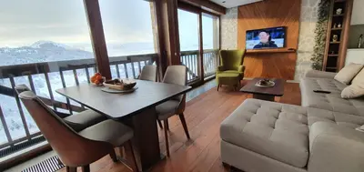 a living room with a table and a couch at Vista47 Zoned II Kopaonik in Kopaonik