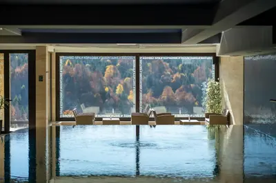 a room with a pool with chairs and a large window at Vista47 Zoned II Kopaonik in Kopaonik