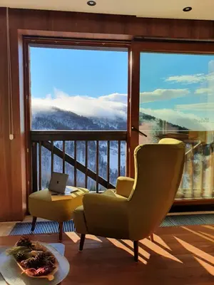 a living room with a chair and a large window at Vista47 Zoned II Kopaonik in Kopaonik