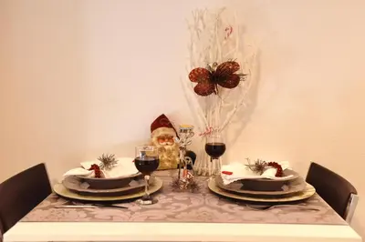 a santa claus sitting at a table with glasses of wine at CIRIĆ APARTMANI in Vrnjačka Banja