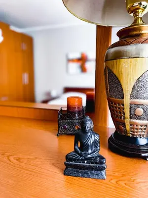 a small figurine sitting on a table next to a lamp at Broj jedan Delux in Soko Banja