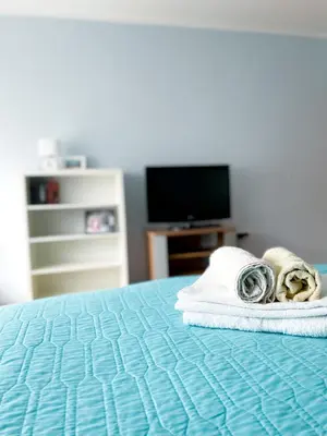 a room with a bed with towels and a television at Broj jedan Delux in Soko Banja