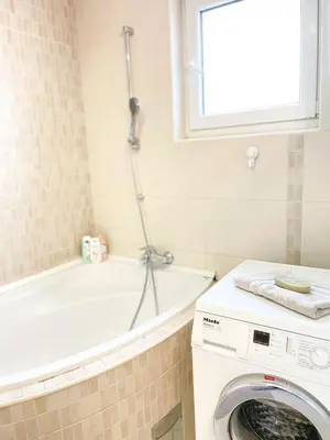 a bathroom with a washing machine and a bath tub at Broj jedan Delux in Soko Banja