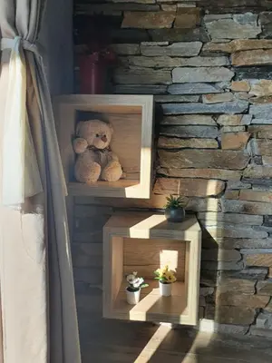 a teddy bear sitting on some shelves in a room at Lux Apartman Lucky in Kopaonik