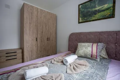a bedroom with a bed with towels on it at Lux Apartman Lucky in Kopaonik