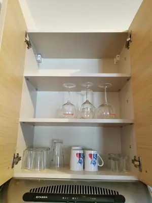 a cupboard with some glasses and mugs on it at Jolly Kop - Apartman 4 in Kopaonik