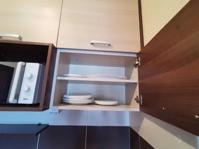 a cupboard with plates and dishes in it at Jolly Kop - Apartman 4 in Kopaonik