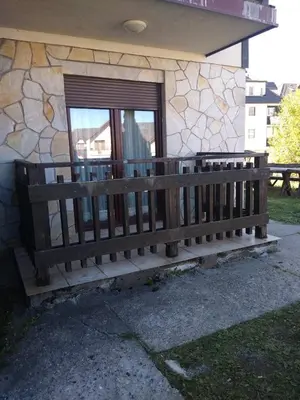 a wooden bench sitting in front of a building at Jolly Kop - Apartman 4 in Kopaonik