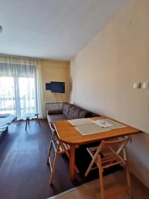 a living room with a table and a couch at Jolly Kop - Apartman 4 in Kopaonik