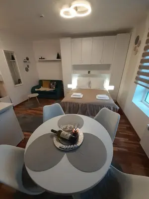 a room with a table with a bottle of wine on it at Lux apartmani Dunja Kopaonik Čardaci - WHITE in Kopaonik