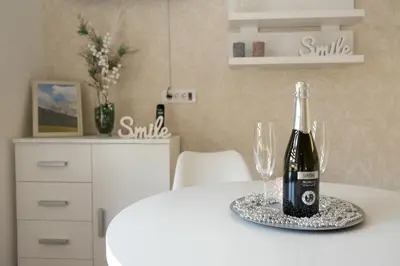 a bottle of wine sitting on a table with two glasses at Lux apartmani Dunja Kopaonik Čardaci - WHITE in Kopaonik