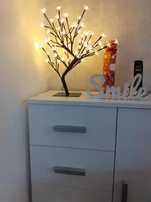 a white dresser with a tree with lights on it at Lux apartmani Dunja Kopaonik Čardaci - WHITE in Kopaonik