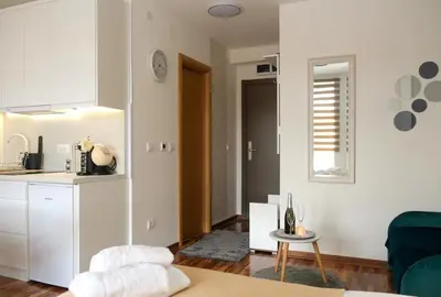 a kitchen and a living room with a couch and a table at Lux apartmani Dunja Kopaonik Čardaci - WHITE in Kopaonik