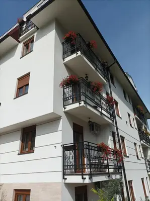 a white building with flowers on balconies at Apartman 8 Extra Vrnjacka Banja in Vrnjačka Banja