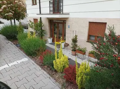 a garden with benches in front of a building at Apartman 8 Extra Vrnjacka Banja in Vrnjačka Banja