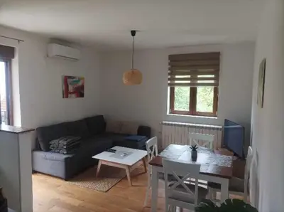 a living room with a couch and a table at Apartman 8 Extra Vrnjacka Banja in Vrnjačka Banja