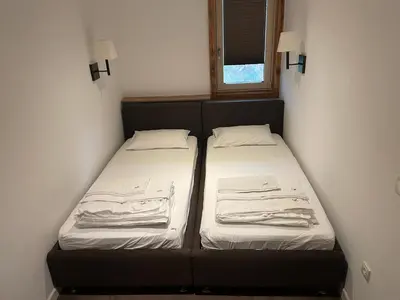 two beds in a small room with a window at MBC - Zupa Wellness & Spa, Kopaonik, Serbia in Kopaonik