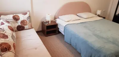 a small bedroom with two beds and a night stand at Sky Apartman 202 in Kopaonik