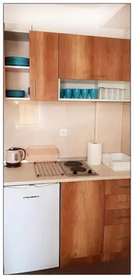 a kitchen with wooden cabinets and a stove top oven at Sky Apartman 202 in Kopaonik