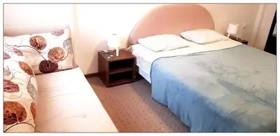 a bedroom with two beds and a night stand with two lamps at Sky Apartman 202 in Kopaonik