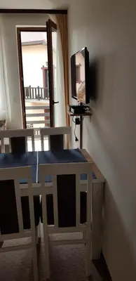 a room with a table and two chairs and a television at Sky Apartman 202 in Kopaonik