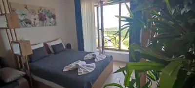 a bedroom with a bed and a plant and a window at SANS Lux Apartman N42 Milmari Kopaonik in Kopaonik