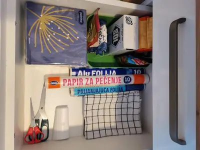 a shelf with a bunch of books and scissors at SANS Lux Apartman N42 Milmari Kopaonik in Kopaonik