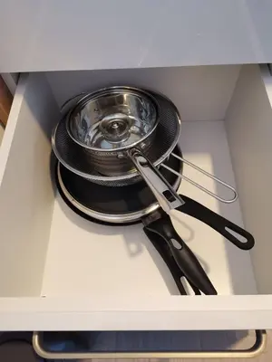 a stack of pans and utensils in a drawer at SANS Lux Apartman N42 Milmari Kopaonik in Kopaonik