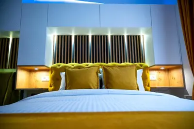 a bedroom with a large bed with yellow pillows at PleasureLUX MILMARI in Kopaonik
