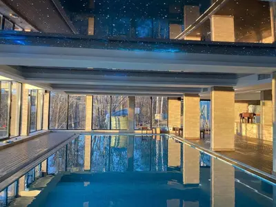 a swimming pool in a house with a large window at PleasureLUX MILMARI in Kopaonik