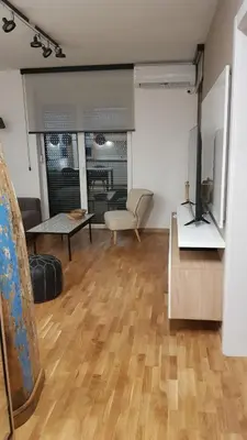 a living room with a wooden floor and a couch at Apartment Ornament Lux in Vrnjačka Banja