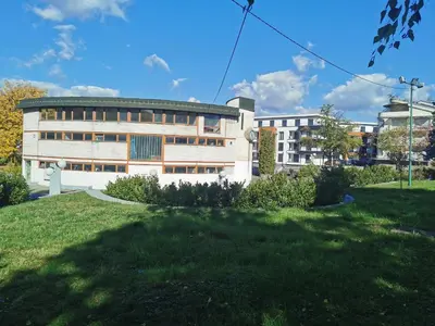 a building with a grassy field in front of it at Apartment Ornament Lux in Vrnjačka Banja