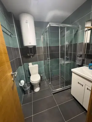 a bathroom with a toilet and a shower and a sink at Apartman Kraljevi čardaci Makica Kopaonik sa garazom in Kopaonik