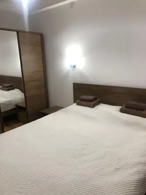 a bedroom with a large white bed and a mirror at Apartman Kraljevi čardaci Makica Kopaonik sa garazom in Kopaonik