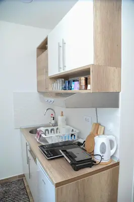 a kitchen with white cabinets and a counter top at Apartmani Krstojević Kopaonik in Kopaonik