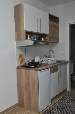 a kitchen with white cabinets and a stove top oven at Apartmani Krstojević Kopaonik in Kopaonik